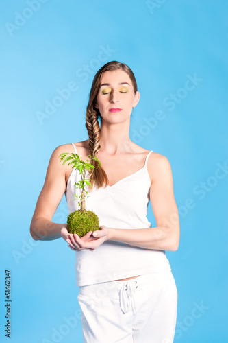 Photo: Young Woman holding a small tree Young Woman holding a small tree