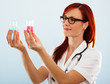 Portrait of a smiling female doctor looking at two flasks