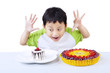 Excited boy eat dessert isolated on white