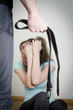 Man with belt coming to his wife. Home violence concept