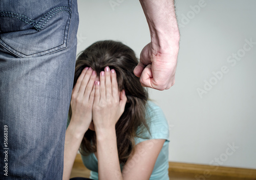 Photo: Home violence concept. Frightened woman and men's fist Home violence concept. Frightened woman and men's fist