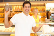 Happy customer in bakery with bags of bread