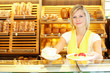 Shopkeeper in baker's shop preparing coffee and cake