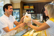 Shopkeeper giving pastry to customer