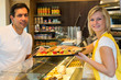 Shopkeeper giving pastry to customer
