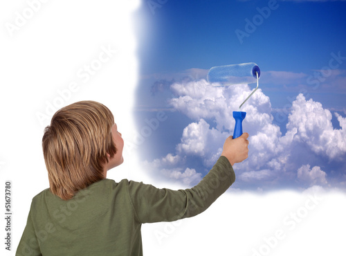 Photo: Adorable child painting a beautiful sky with a roller Adorable child painting a beautiful sky with a roller