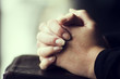 Folding Hands over a Bible