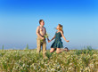 Photo: The happy young pair in the field of chamomiles jumps.. The happy young pair in the field of chamomiles jumps..