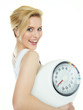Beautiful girl with scale is proud to lose weight