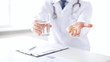 male doctor hands with pills and glass of water