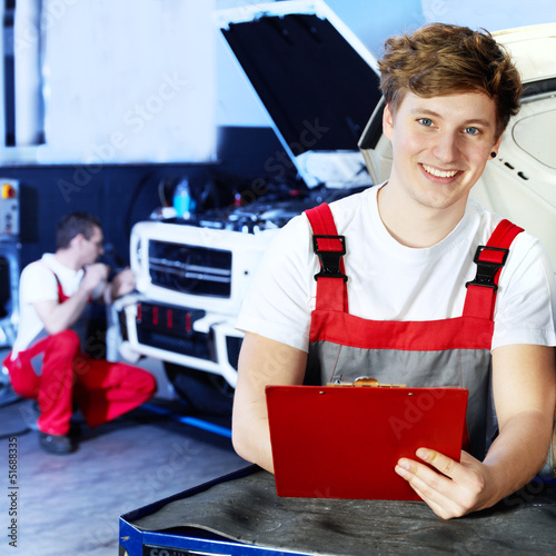 Photo: Apprentices for car mechanic is satisfied with his job Apprentices for car mechanic is satisfied with his job