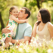 Foto: Happy mother, father and daughter in the park Happy mother, father and daughter in the park