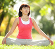 Foto: Pretty woman doing yoga exercises in the park Pretty woman doing yoga exercises in the park
