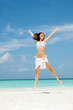 Photo: happy young woman jumping on the beach happy young woman jumping on the beach