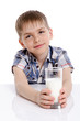 Foto: Happy kid with a glass of milk leaning on the table Happy kid with a glass of milk leaning on the table