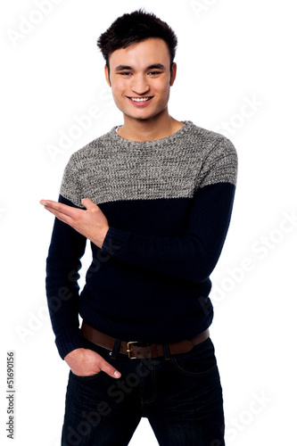 Photo: Casual young guy pointing away Casual young guy pointing away