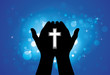 Person praying or worshiping with holy cross in hand
