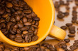 Photo: Yellow cup with many coffee beans Yellow cup with many coffee beans