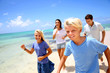 Cheerful family running on a sandy beach