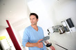 Man with blue shirt holding coffee pot