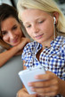 Teenager using smartphone with adult beside her