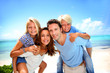 Parents giving piggyback ride to kids at the beach