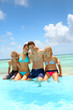 Family sitting on the side of an infinity pool