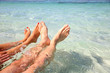 Closeup of couple's feet in lagoon water