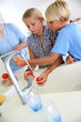 Kids washing fresh tomatoes for salad