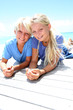 Blond teenagers laying on pool deck in summer