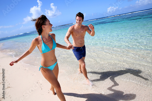 Photo: Couple running on a sandy beach Couple running on a sandy beach