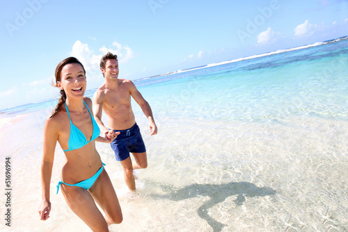Photo: Couple running on a sandy beach Couple running on a sandy beach