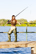 Photo: young woman fishing at pond young woman fishing at pond