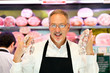 Man showing a salami in a grocery store