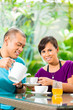 Photo: Asian couple having coffee on home porch Asian couple having coffee on home porch