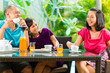 Photo: Asian friends having coffee on home porch Asian friends having coffee on home porch