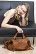 Foto: portrait of woman with a handbag lying on sofa portrait of woman with a handbag lying on sofa