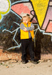 Confident little boy posing in front of graffiti
