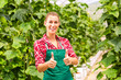 Foto: Female commercial gardener in green house Female commercial gardener in green house