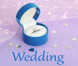 Beautiful box with wedding ring on purple background