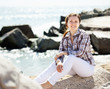 Foto: woman enjoying on stone at sea woman enjoying on stone at sea