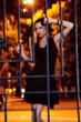 Pretty woman posing in cage outdoors at night