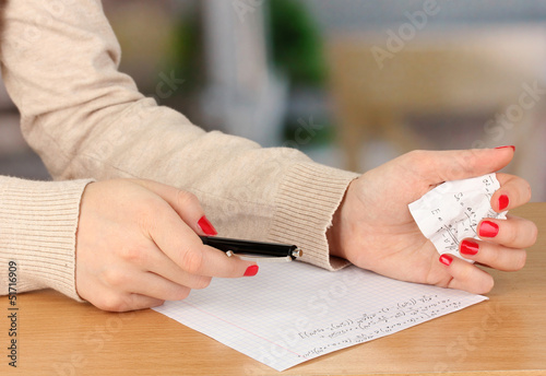 Photo: Write off exam on wooden table on room background Write off exam on wooden table on room background
