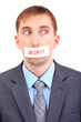 Young businessman with a band on his mouth isolated on white