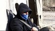 Aggressive man with a machete leaning against the wall
