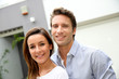 Couple leaning on fence in front of home