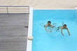 Foto : Upper view of couple swimming in infinity pool Upper view of couple swimming in infinity pool