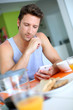 Man using smartphone while having breakfast