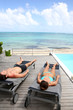 Couple relaxing in long chairs in front of the sea