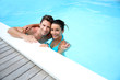 Portrait of cheerful couple in swimming-pool